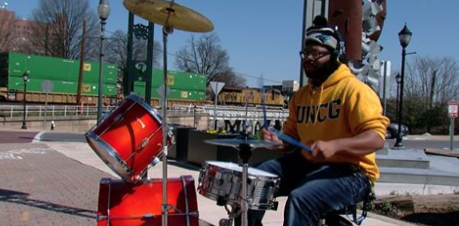 video capture of student playing drums outside