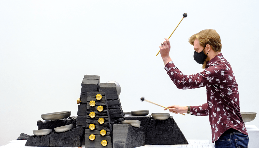 musician plays sound sculpture