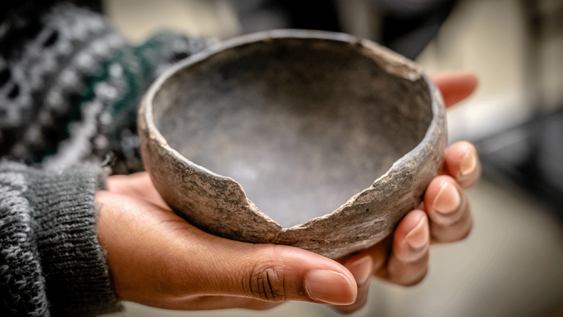hands cup an ancient bowl