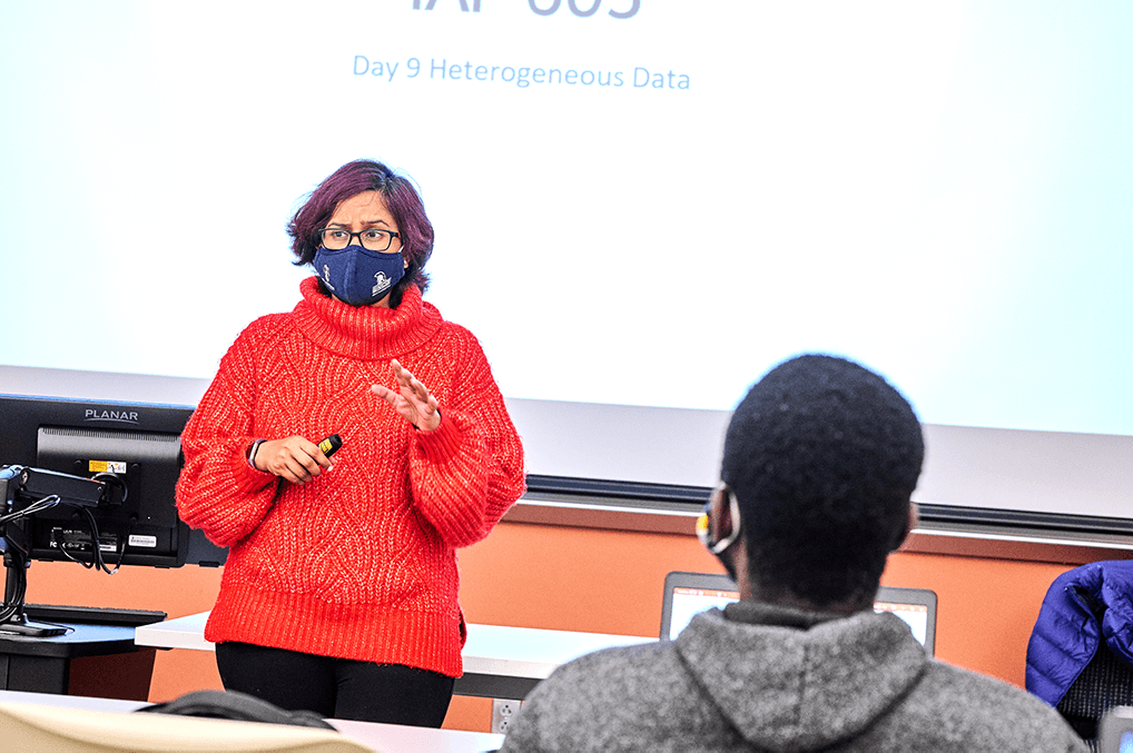 masked woman teaches while male student watches