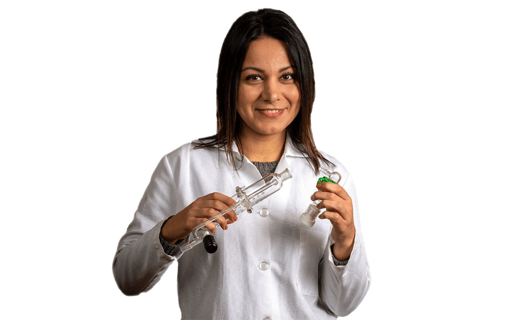 Dr. Shabnam Hematian wears labcoat and holds chemistry instruments