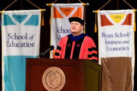 Dean John Z. Kiss speaking at a podium at Commencement