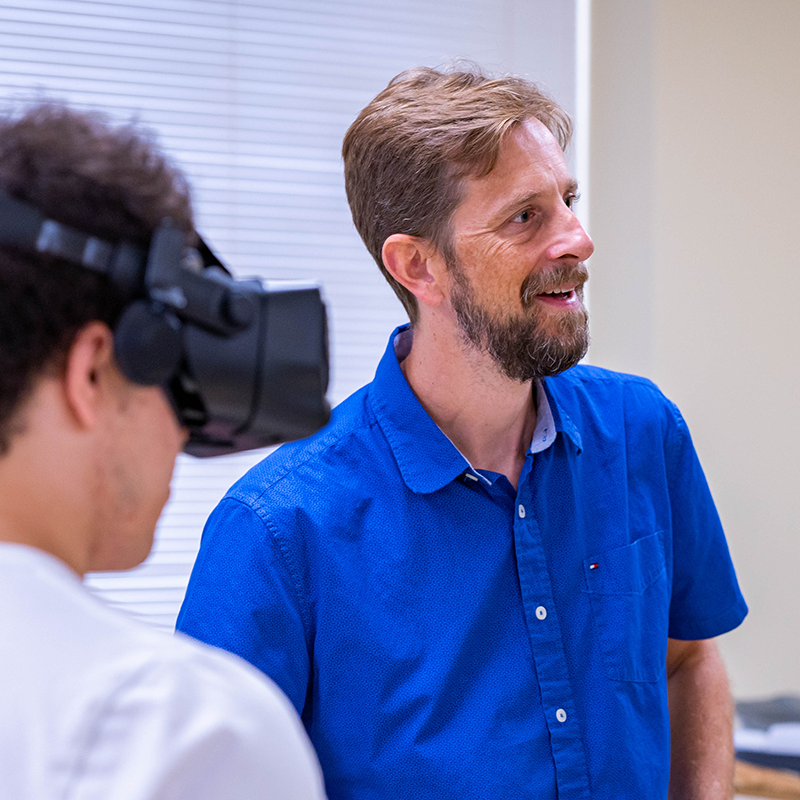 Dr. Regis Kopper with student wearing VR headset
