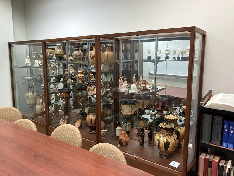 display case of ancient greek and roman artifact replicas