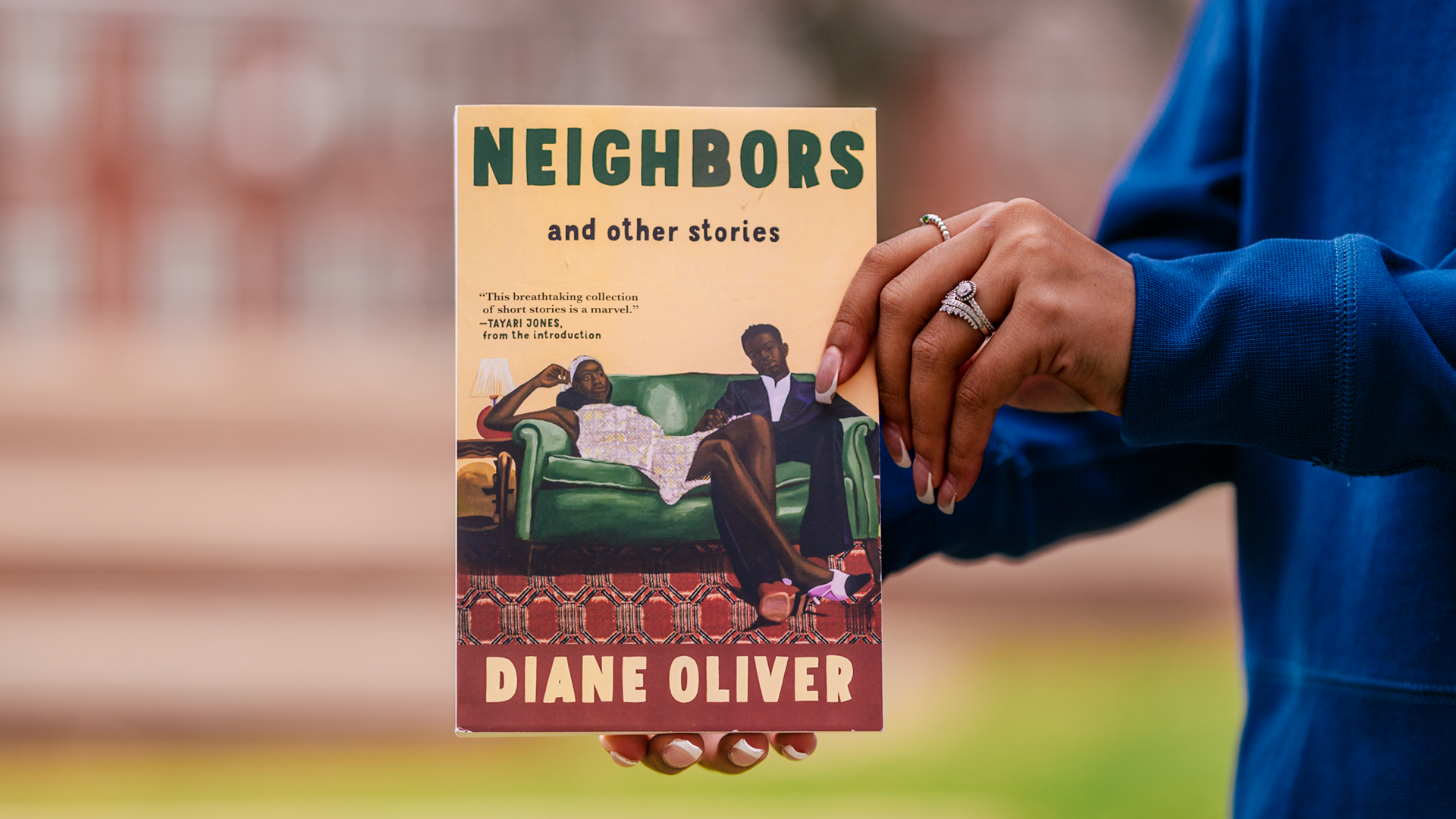Hands holding copy of book by Diane Oliver, "Neighbors and Other Short Stories"