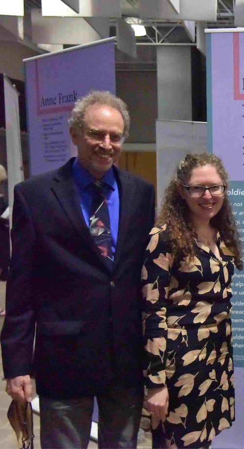 A curator and a composer are standing side-by-side and smiling for the photo.