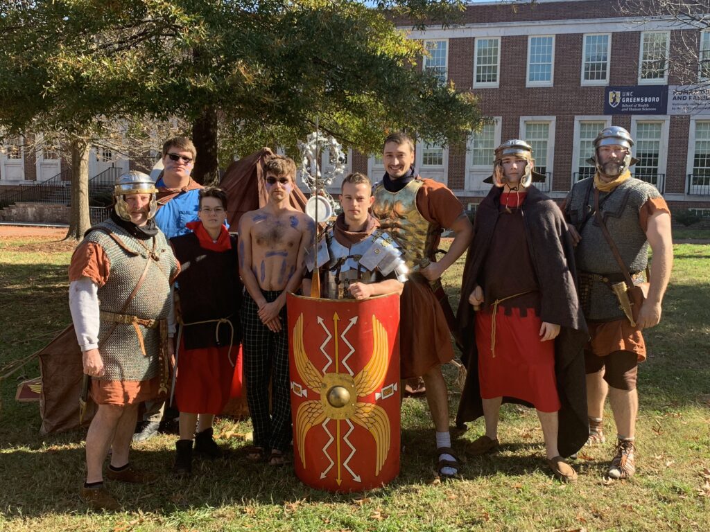 Group of people dressed in Ancient Greek attire posing for a photo