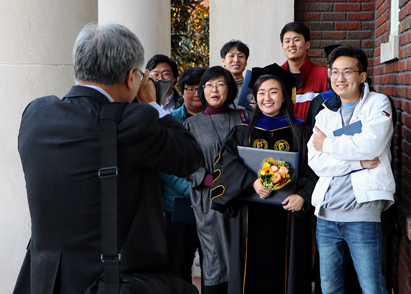 Family poses with PhD graduate after Doctoral hooding