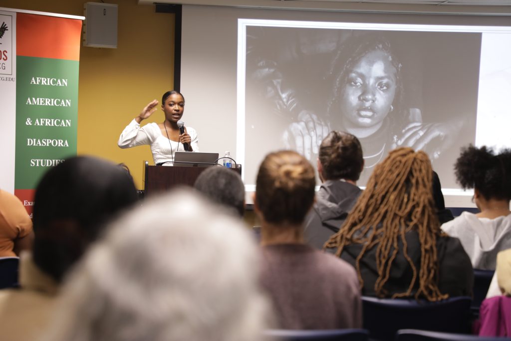 Woman giving speech at conference in front of crowd.