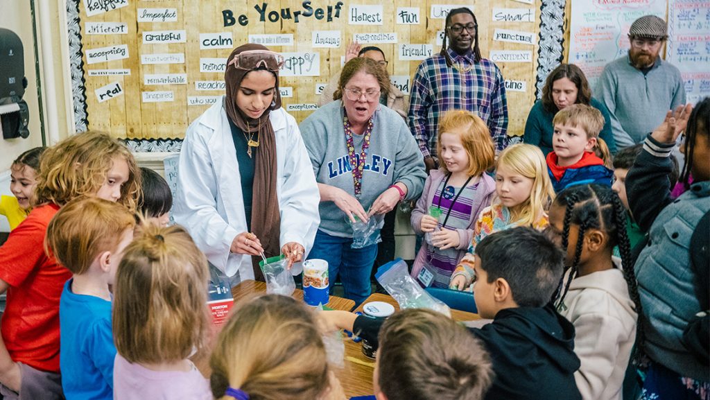 UNCG Chemistry students lead science experiments surrounded by Lindley Elementary students and teacher