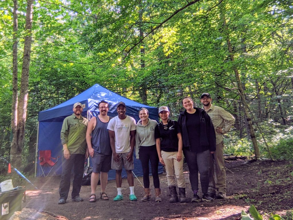 Group photo of McLean and student researchers in the woods