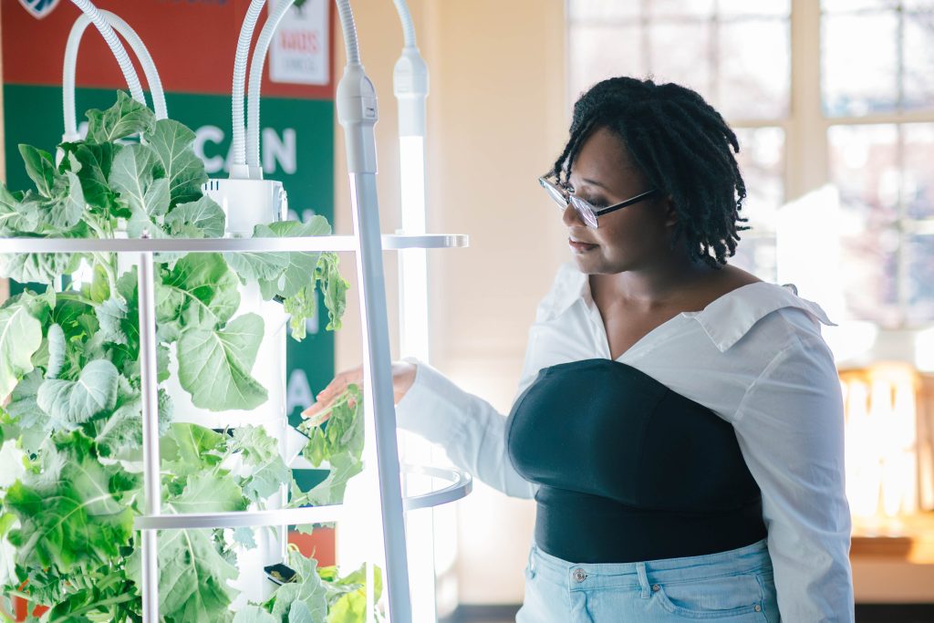 a student tending to an indoor vertical garden