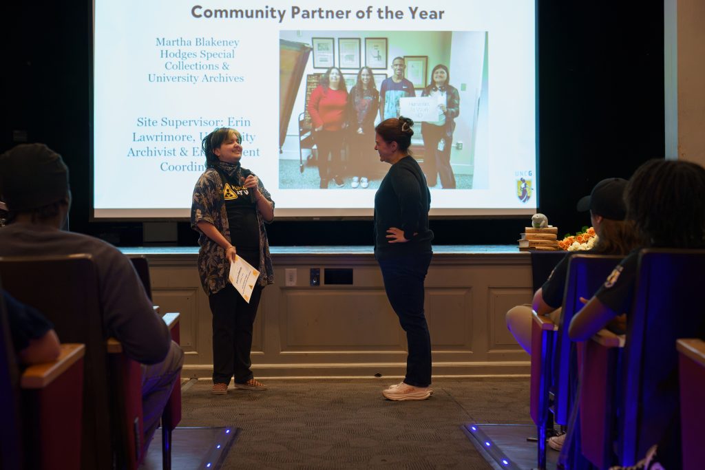 Humanities at Work Intern Piettr Codr stands with site supervisor Erin Lawrimore, while presenting her with the Community Partner of the Year award.