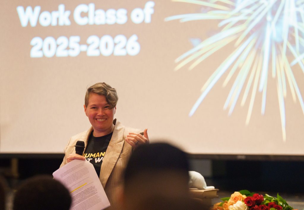 Dr. Lauren Shook stands, smiling and looking toward the intern class, while making her opening remarks.