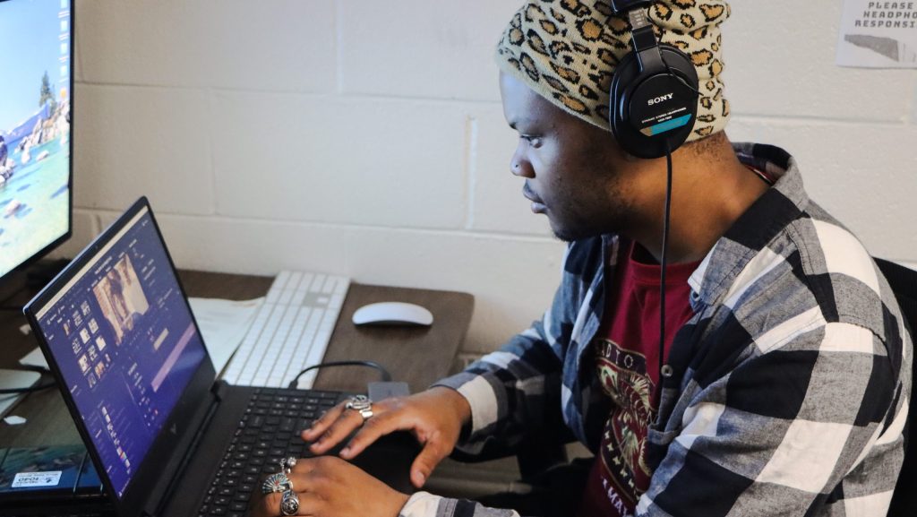 Cole Smith works at a computer editing video footage on his laptop for his documentary project about his family's history and business legacy.
