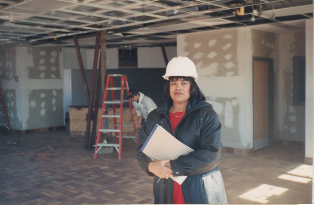 Archival photograph of a McDonald's franchise owner standing inside a restaurant under construction while reviewing plans.