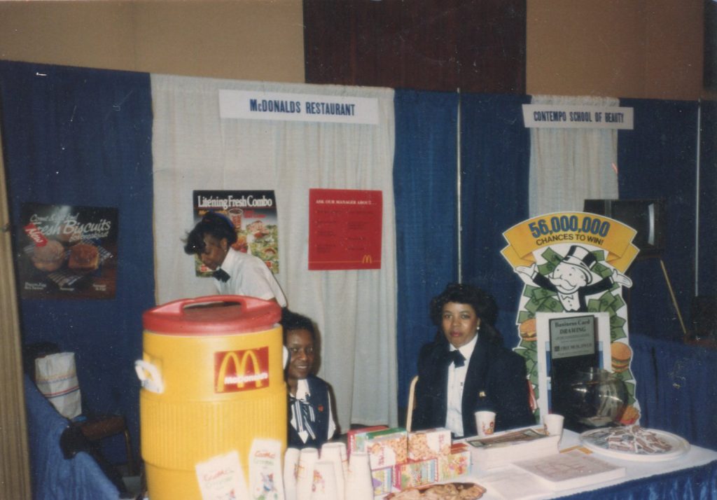Archival photograph of a McDonald's promotional booth at a community or business expo featuring restaurant marketing materials and staff.