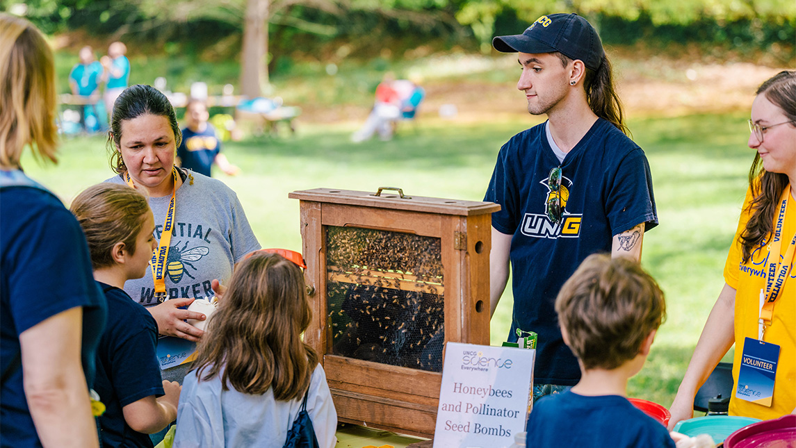 Dr. Kaira Wagoner and Plant & Pollinator Center staff show children a live bee observation hive at Science Everywhere.