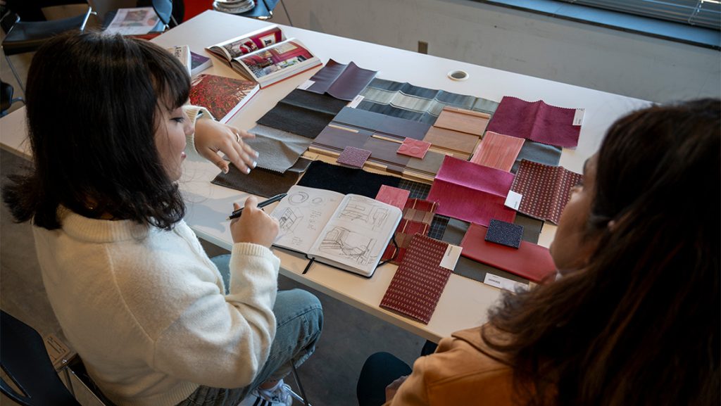a student and instructor looking at fabric samples